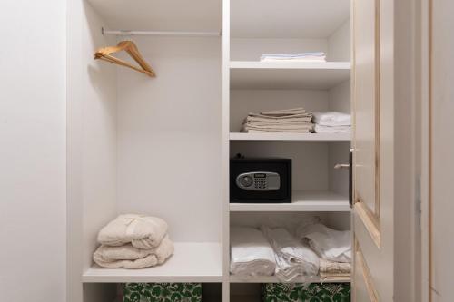 een kast met witte planken met een magnetron en handdoeken bij Villa Lucija in Katun Gračanski