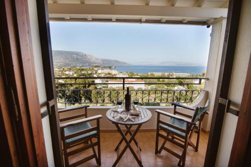 balcón con mesa, sillas y vistas al océano en Giorgos apartments en Dassia