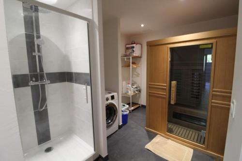 uma casa de banho com um chuveiro e uma máquina de lavar roupa em Au Coin des Fées em Les Forges