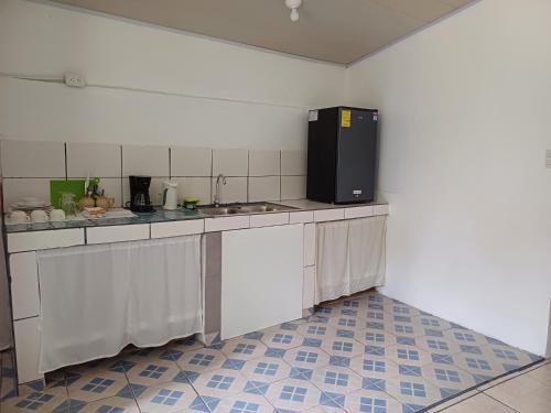 uma cozinha com balcões brancos e um frigorífico preto em Mirians Place Drake em Drake