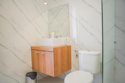 a bathroom with a toilet and a sink and a mirror at Cansa Seminyak in Seminyak