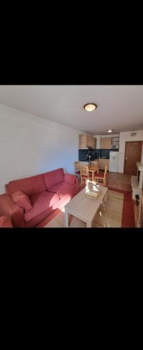 a living room with a red couch and a table at One bedroom Apartment in Bansko