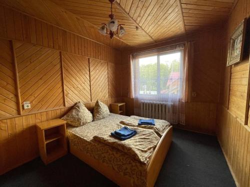 a bedroom with a bed with two blue towels on it at Едельвейс-Будапешт in Yasinya