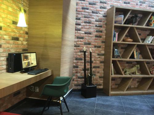 a room with a desk with a computer and a brick wall at TRYP by Wyndham Mexico City World Trade Center Area in Mexico City