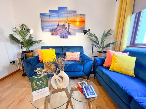 ein Wohnzimmer mit einem blauen Sofa und einem Glastisch in der Unterkunft Happy Sandy Feet - Modern, Cozy & Warm Holiday Home with Lovely Sea Views in Youghal`s Heart - Top-Notch Electric Heaters - Long Term Price Cuts in Youghal