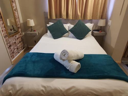 um quarto com uma cama com toalhas em The Crooked Forest em Pretoria