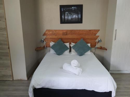 a bedroom with a bed with two towels on it at The Crooked Forest in Pretoria