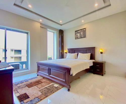 a bedroom with a bed and a large window at 1-Bed Elegant Condo at Eiffel TW in Rāmkot