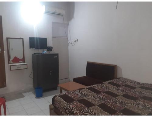 a bedroom with a bed and a dresser and a television at Hotel Vishal, Gaya in Gaya
