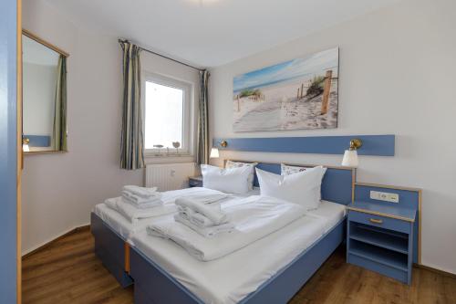 a bedroom with a blue and white bed with white pillows at Yachthafenresidenz-Wohnung-8204-852 in Kühlungsborn