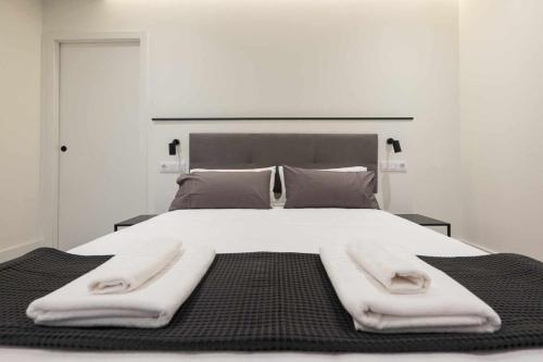 1 cama blanca grande con 2 toallas en AT Presidente Nº3 apartamento privado completo en Sevilla