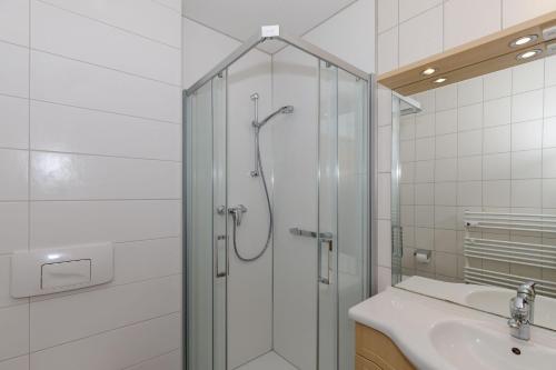 a shower with a glass door next to a sink at Yachthafenresidenz-Wohnung-8204-852 in Kühlungsborn