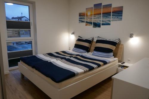 1 dormitorio con 1 cama con almohadas azules y blancas en Dahmer Strand 16 Sonnenloge, en Dahme