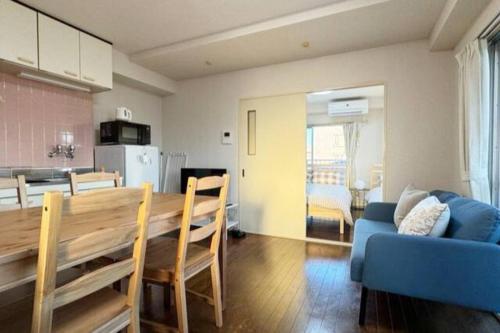 a kitchen and dining room with a table and a blue couch at Sun white Gyoutoku 301 in Tokyo