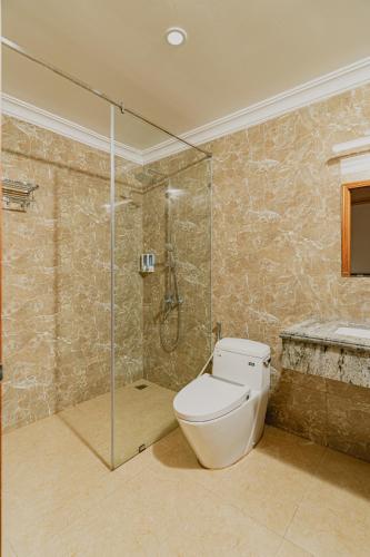 a bathroom with a toilet and a glass shower at Valentina Resort & Spa Phu Quoc in Phu Quoc