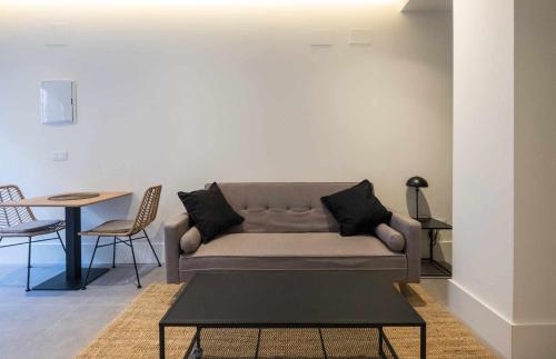 uma sala de estar com um sofá e uma mesa em AT Presidente Nº4 apartamento privado completo em Sevilha