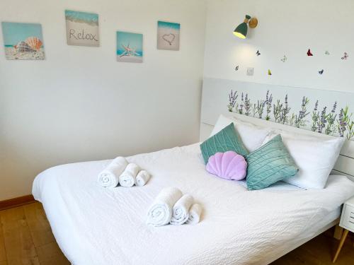 Un dormitorio con una cama blanca con toallas. en Happy Sandy Feet - Modern, Cozy & Warm Holiday Home with Lovely Sea Views in Youghal`s Heart - Top-Notch Electric Heaters - Long Term Price Cuts, en Youghal