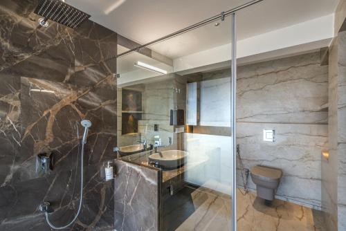 a bathroom with a shower and a sink and a toilet at SaffronStays Mountain Rizz in Panchgani