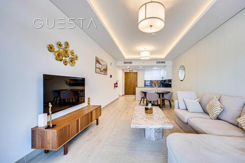 a living room with a couch and a tv at Azizi Mina The Palm, Free beach and pool access in Dubai