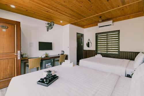 a bedroom with two beds and a television in it at Valentina Resort & Spa Phu Quoc in Phu Quoc