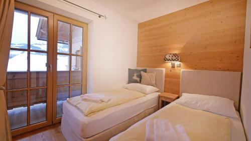 two beds in a room with a window at Chalet Wohnung Wilder Kaiser in Kitzbühel