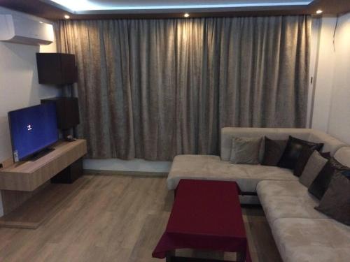 a living room with a couch and a tv at Luxury Two Bedroom Flat in Blagoevgrad