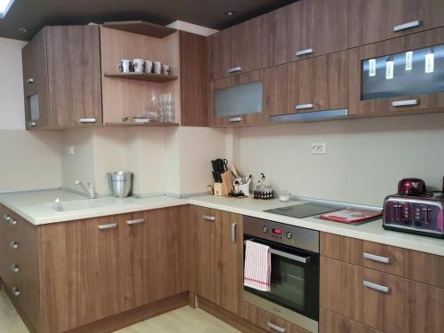 a kitchen with wooden cabinets and a stove top oven at Luxury Two Bedroom Flat in Blagoevgrad