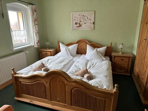 a large wooden bed with two dolls laying on it at Weißer Stein Jonsdorf in Kurort Jonsdorf