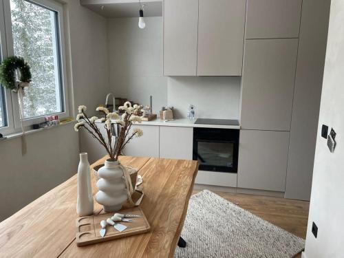 a kitchen with a wooden table with a vase on it at GO Jahorina by Olympic Gardens in Jahorina