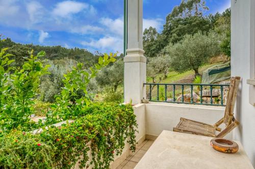 a balcony with a chair and a view of the mountains at Abrigo do Castelo - Pica-Pau in Ourém