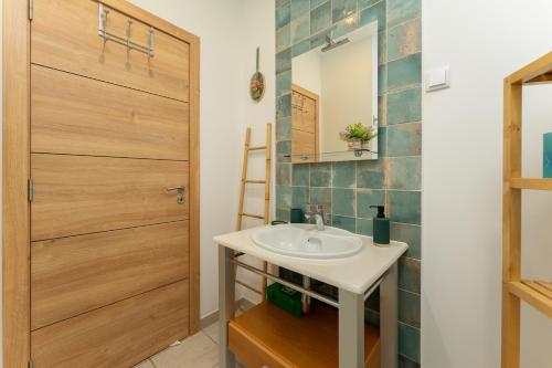 a bathroom with a sink and a wooden door at Abrigo do Castelo - Pica-Pau in Ourém