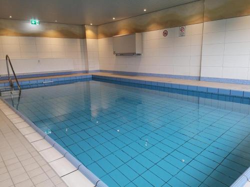duży basen z niebieską wodą w obiekcie Strandhotel Wohnung 42 w mieście Dahme