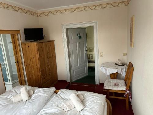 a room with two beds and a table and a television at Weißer Stein Jonsdorf in Kurort Jonsdorf