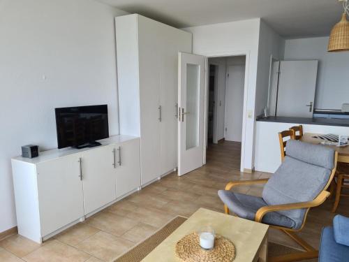 a living room with a tv and a couch and a table at Strandhotel Wohnung 48 in Dahme