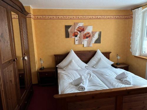 a bedroom with a bed with white sheets and pillows at Weißer Stein Jonsdorf in Kurort Jonsdorf