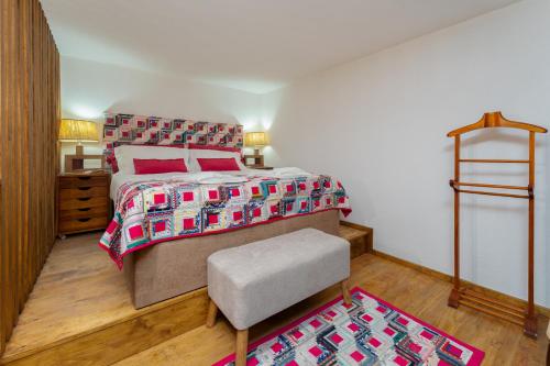 a bedroom with a bed and a chair in it at Abrigo do Castelo - Pica-Pau in Ourém