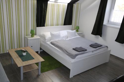 a small bedroom with a bed and a table at Hortobágyi Kemencés Vendégház in Hortobágy