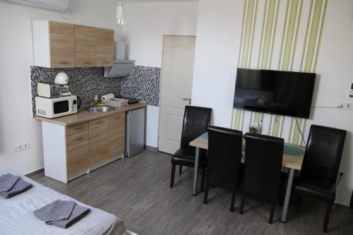 a small room with a kitchen and a table and chairs at Hortobágyi Kemencés Vendégház in Hortobágy