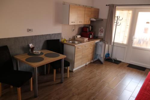 a kitchen with a table and a small kitchen with a sink at Hortobágyi Kemencés Vendégház in Hortobágy