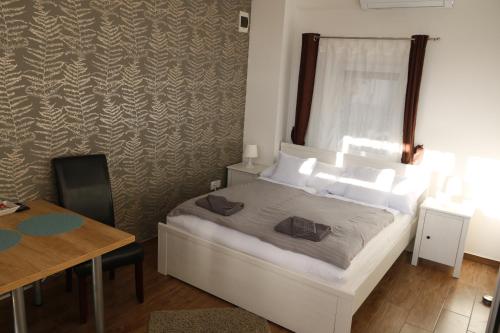 a bedroom with a bed and a table and a desk at Hortobágyi Kemencés Vendégház in Hortobágy