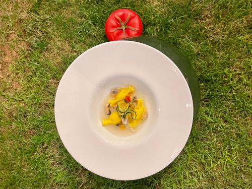 a white plate with a bowl of food on the grass at Sopramare Resort in Piano di Sorrento