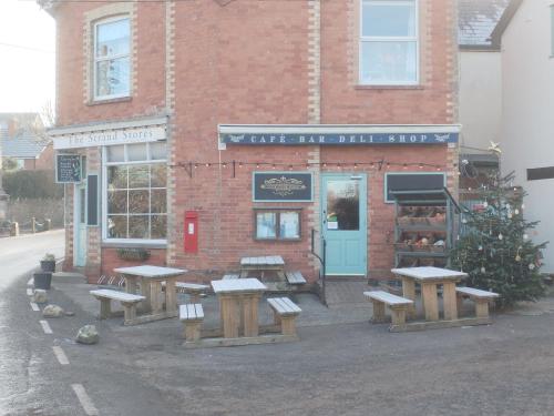 a group of benches in front of a brick building at Spacious and sunny accommodation with Underfloor heating throughout in Culmstock