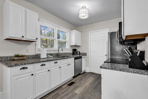 a kitchen with white cabinets and granite counter tops at Charlotte Luxury Home NoDa in Charlotte