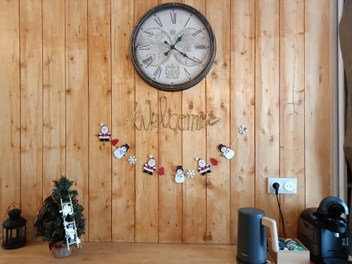 a clock on a wooden wall with christmas ornaments at Studio Gare&centre de Grenoble in Grenoble