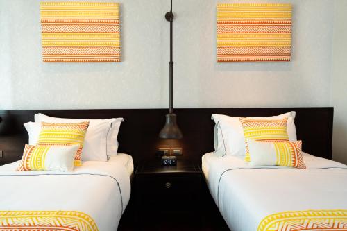 two beds sitting next to each other in a room at Mintra Hotel in Vientiane