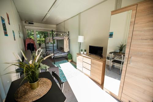 uma sala de estar com uma mesa e uma televisão e um quarto em Maszoperia Sun4hel Kite & Wind & Surf em Jastarnia