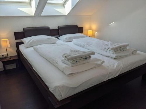a large bed with white sheets and towels on it at Yachthafenresidenz-Wohnung-8411-871 in Kühlungsborn
