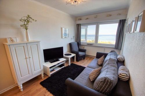 ein Wohnzimmer mit einem Sofa und einem TV in der Unterkunft Strandhotel, App 5SH221 in Heiligenhafen