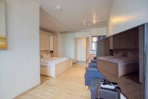 Zimmer mit 2 Betten und einem TV. in der Unterkunft Strandhotel, App 3SH219 in Heiligenhafen