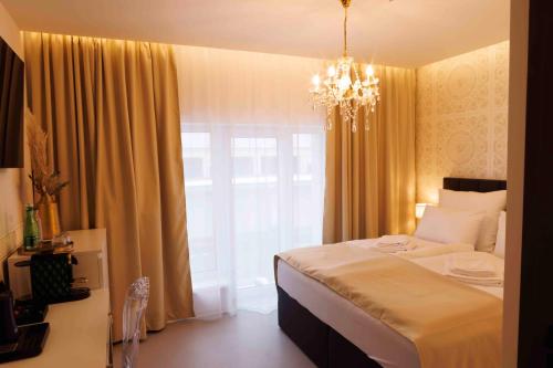 a bedroom with a large bed and a chandelier at Villa Mala Praha Experience in the Center of Žilina in Žilina